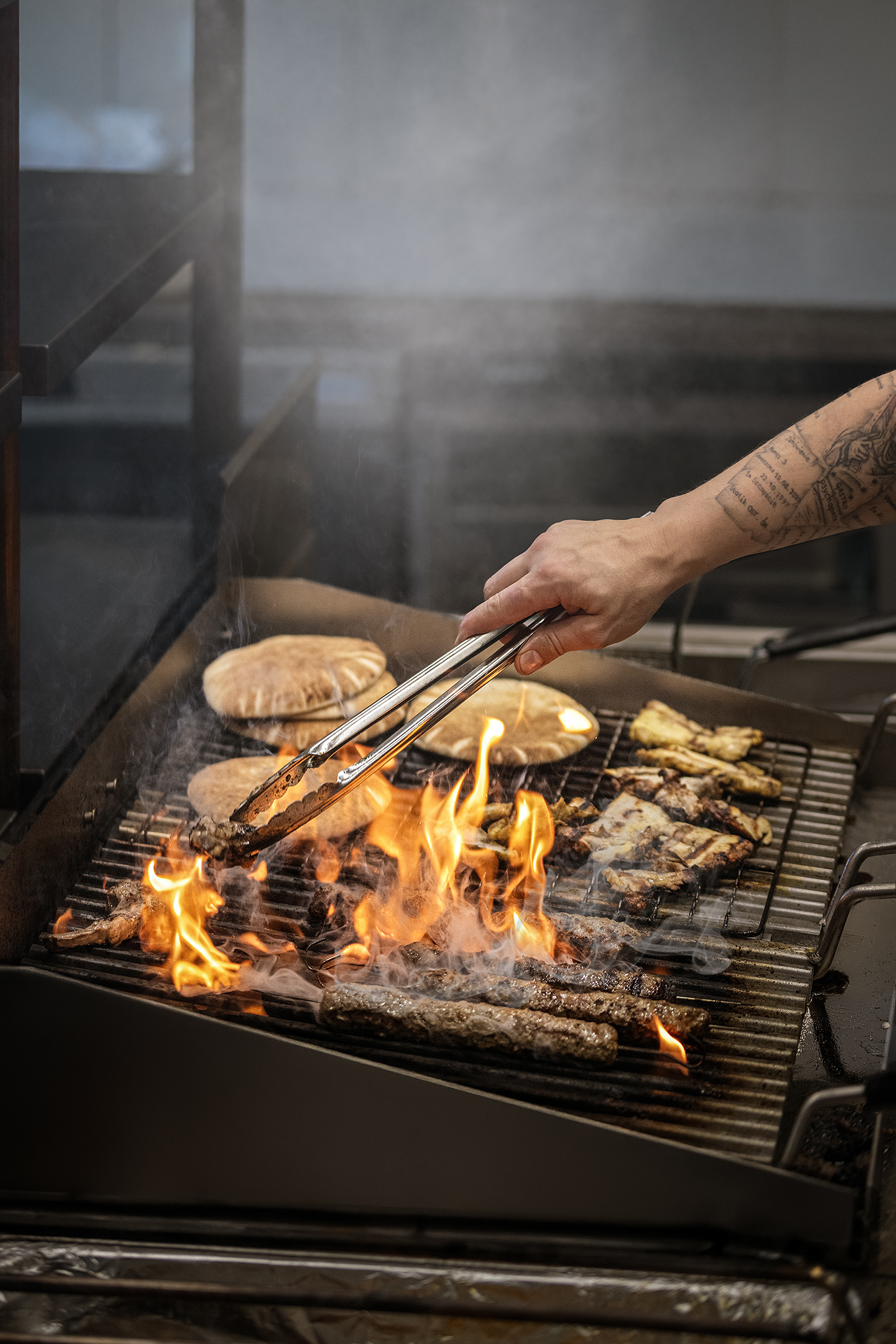 Szef kuchni grillujący tradycyjne bliskowschodnie jedzenie na lava grill